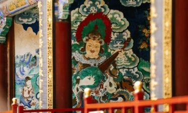 Colorful mural depicting traditional Chinese art inside a temple, featuring intricate details and symbolic imagery.