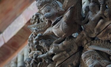 Close-up of detailed stone carvings at a temple in Lalitpur, Nepal, showcasing traditional Nepali artistry.