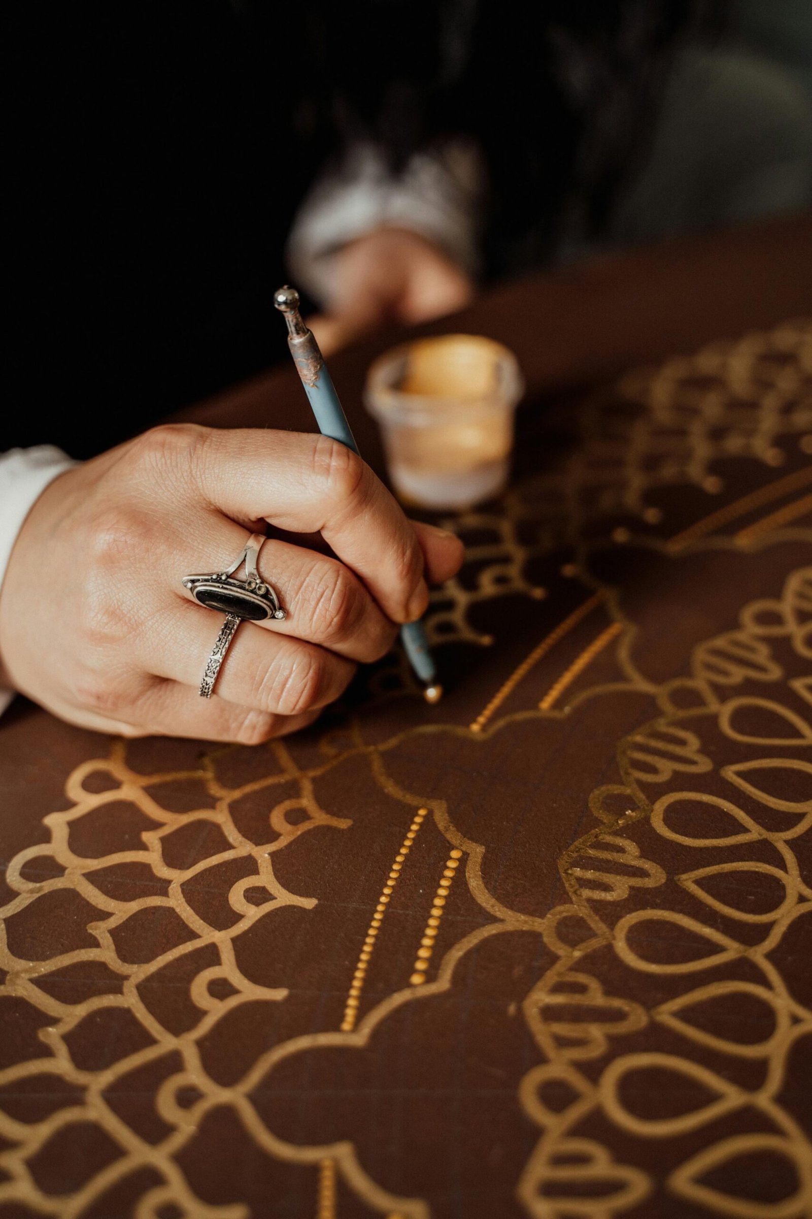 Close-up of a hand creating intricate dot painting art in Erfurt, capturing details and creativity.